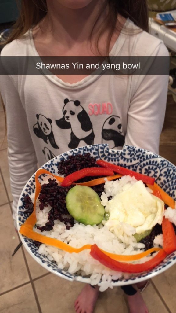 Girl holding yin and yang food bowl
